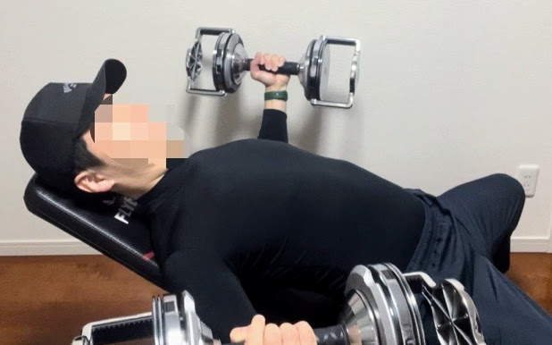インクラインベンチを使ってインクラインダンベルフライを行っている写真